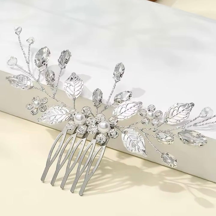 Detalle de hojas metálicas y perlas en peineta novia elegante