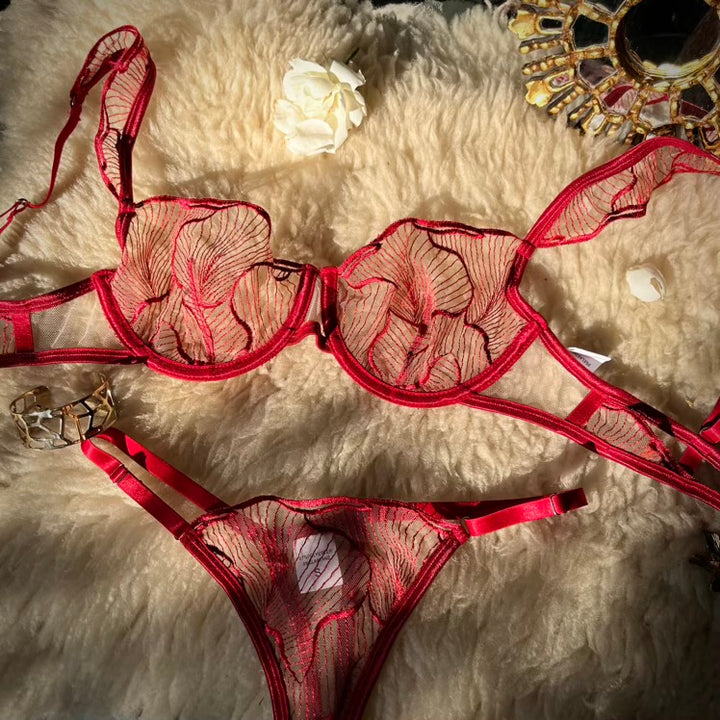 Sostén y colaless Dora rojo dispuestos sobre superficie neutra