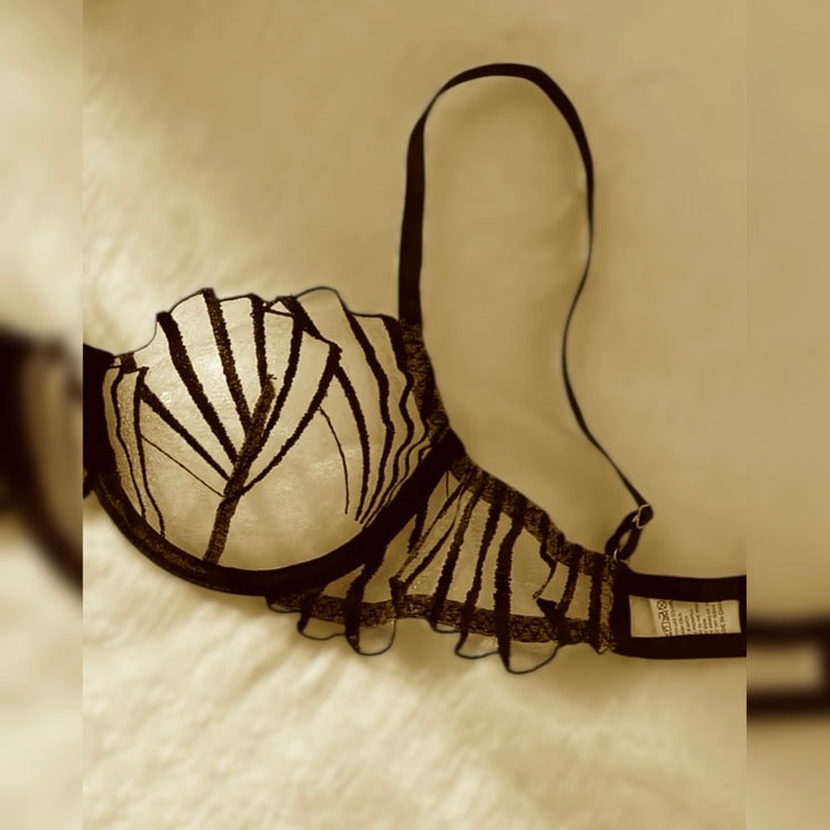 Detalle sostén encaje negro con diseño de tiras