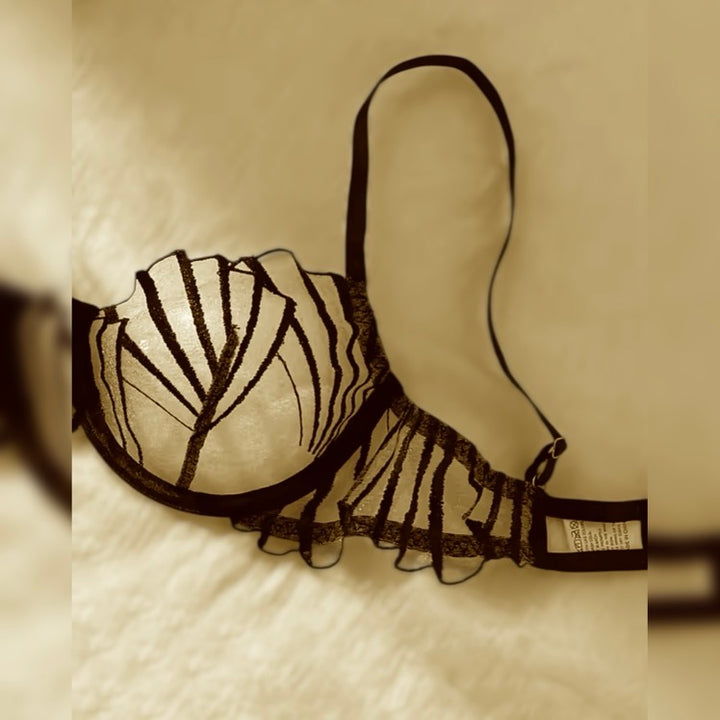 Detalle sostén encaje negro con diseño de tiras